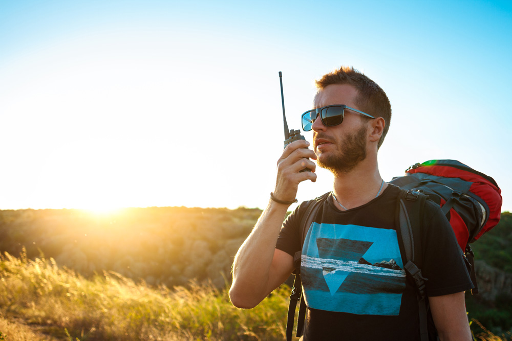 Persona utilizando un walkie talkie en exterior durante una ruta de montaña