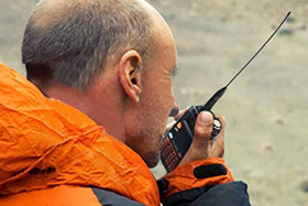 Usuario profesional comunicándose con un walkie talkie con licencia en exterior