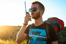 Adulto usando walkie talkie PMR 446 sin licencia durante una ruta de senderismo